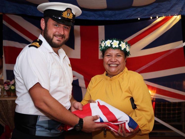 Lt Cdr Millyard, Executive Officer of HMS Tamar, presents The Honourable J Udch Sengebau, the Deputy President of Palau, with the ship's White Ensign after a sunset ceremony held onboard the ship in July 2022 (Picture: Crown Copyright).