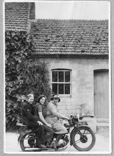 She was a rider. Three young women posing on a motorcycle.